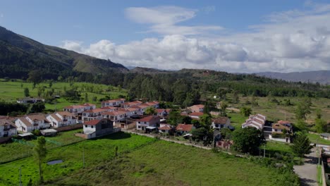 as the drone ascends, a patchwork of terracotta rooftops and colonial-era buildings comes into view, framed by rolling hills and verdant valleys