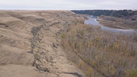 dry autumn aerial down lower bow river valley with eroded hillside