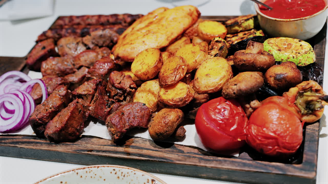 Juicy grilled meat served with golden roasted potatoes, tomatoes, mushrooms, and sauce