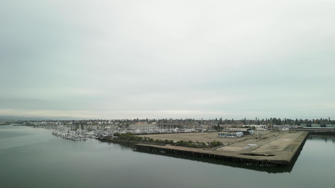 Drone footage over Mariner Square, showcasing an array of docked boats and the harmonious blend of urban and natural elements.