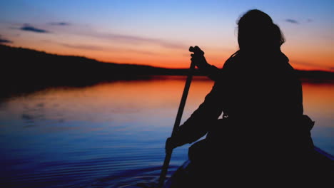 vista estática de una mujer remando en una canoa en el lago