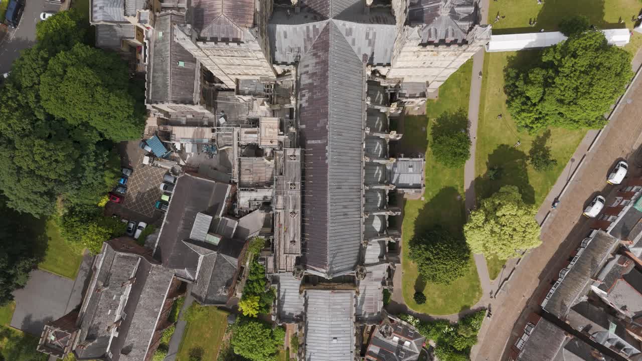 세터 대성당 (exeter cathedral) 의 위에서 아래로 드론으로 볼 때, 주요 복원 작업이 진행 중이며, 초록색과 인근 건물로 둘러싸여 있습니다.