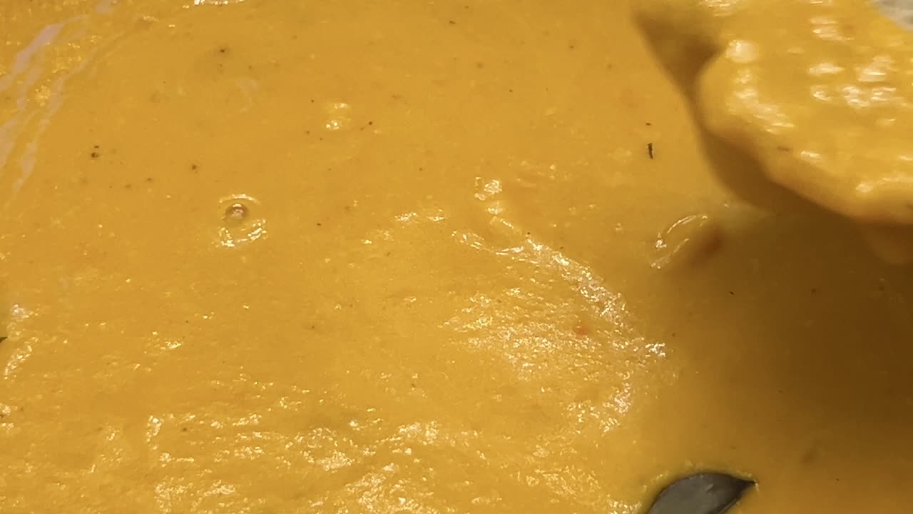 sumergiendo el pan en la sopa de calabaza de cerca