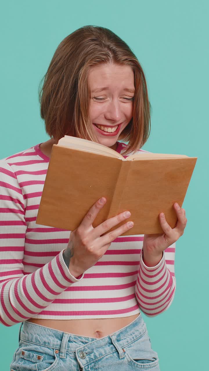Giovane donna che legge un libro di favole divertente e interessante, che ride, che si diverte, che ha hobby, che studia.