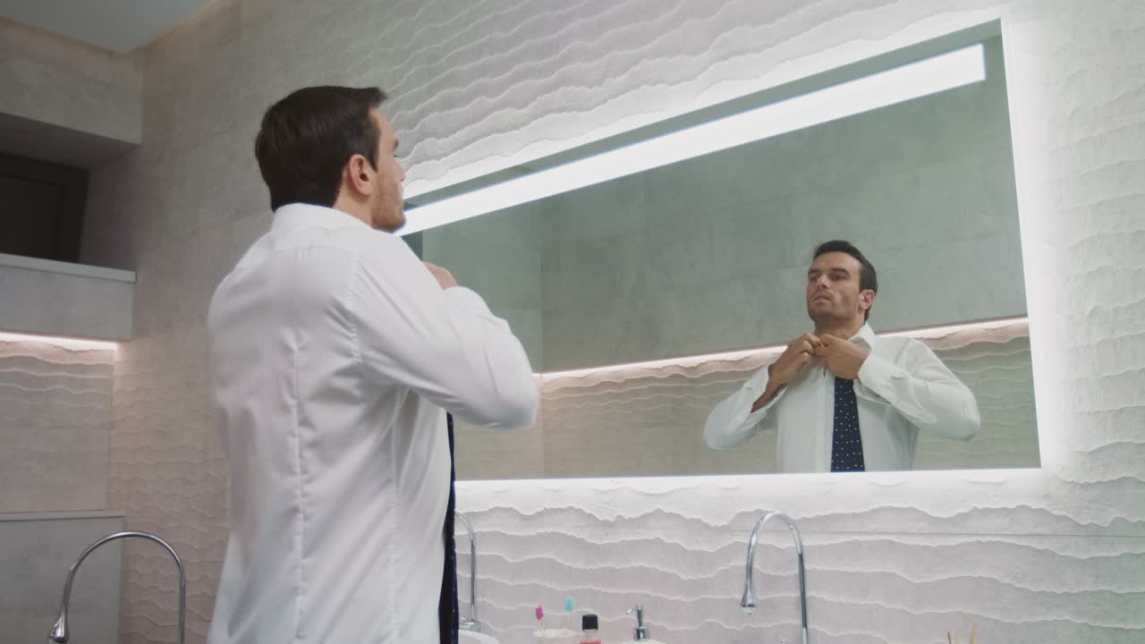 hombre de negocios abotonando camisa baño de lujo. hombre feliz vestido en casa privada.