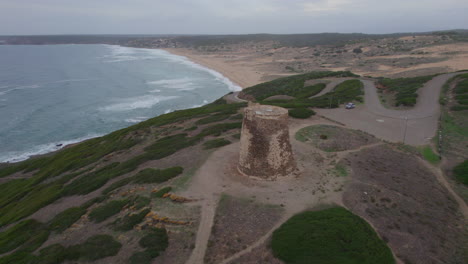 aerial view with crane movement over the flumentorgiu tower and overlooking the torre dei corsari beach