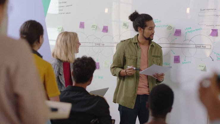 creative team meeting mixed race businessman presenting project development strategy on whiteboard diverse group of business people working together sharing ideas enjoying leadership support
