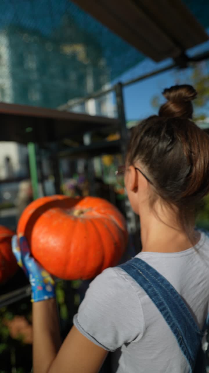 농부 의 시장 에 있는 여자 가 호박 을 보고 있다
