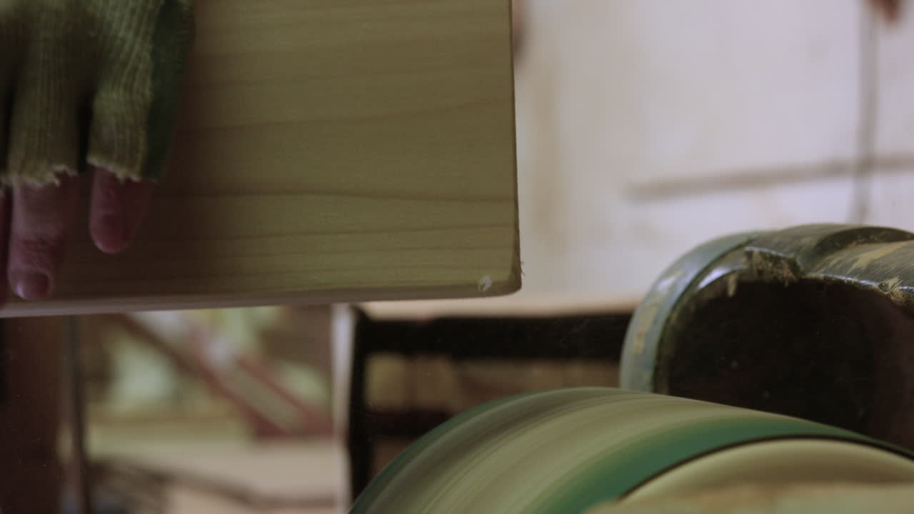 hombre lijando el bisel en el borde de la madera en el taller del garaje - cerrar