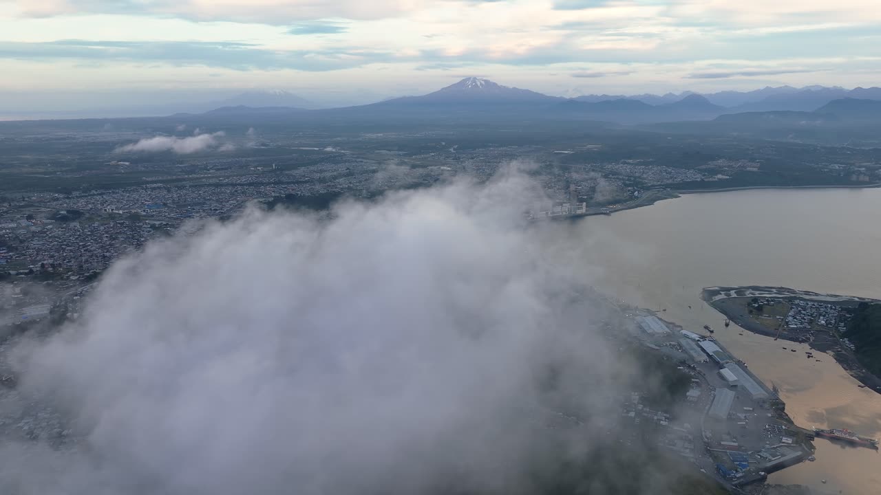 칠레 호수 지구에 있는 푸에르토 몬트 만과 항구를 드러내기 위해 구름을 지나 날아가는 조감도