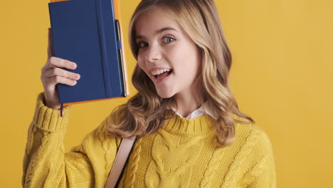 happy teenage caucasian girl student holding notebooks.