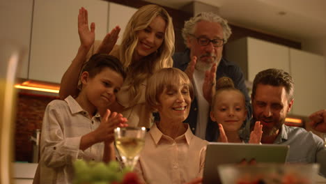 family using tablet for video call. people congratulating relatives at camera