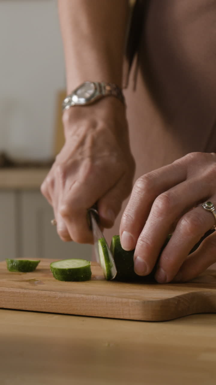 Cutting cucumber on a wooden board