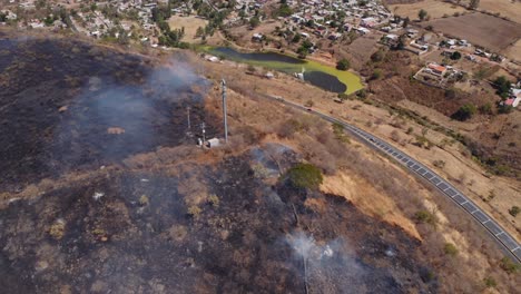 helicóptero extinguiendo quemaduras dañadas colina humeante vista aérea con vistas a la ciudad desastre natural