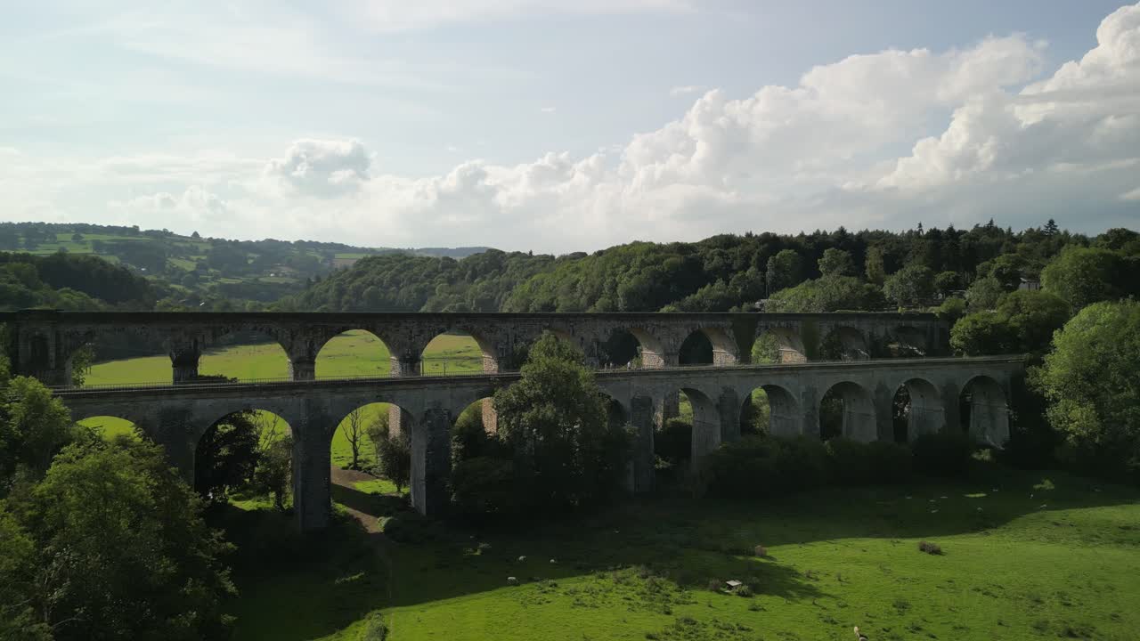 Chirk Aqueduct and Railway Viaduct approach, people crossing canal towpath - aerial drone fly forward and valley reveal - Welsh, English border, Sept 23