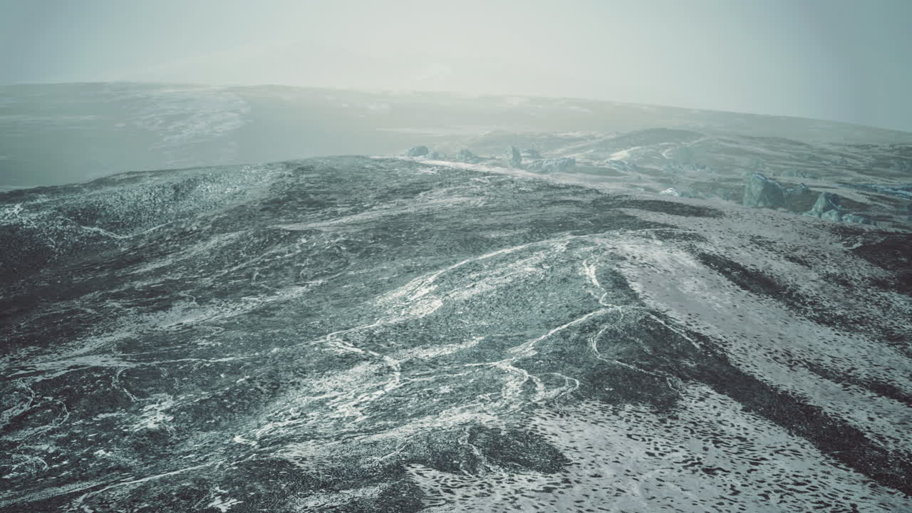 Snow covered mountains with rocky terrain under overcast sky