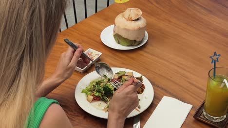 woman eating salad at a tropical restaurant