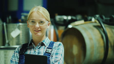 portrait of a laboratory assistant woman in protective glasses on the background of wine barrels