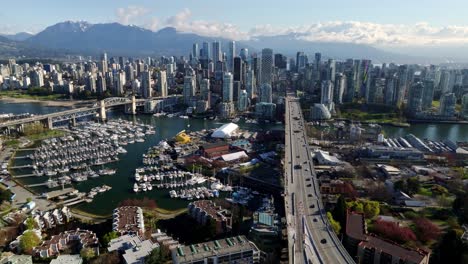 an elevated view from south granville captures vancouver’s dynamic skyline, busy marina, and the scenic mountains beyond in vancouver, british columbia, canada - wide shot