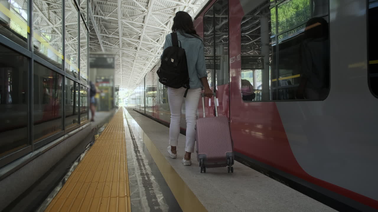 mujer caminando hacia el tren en la estación