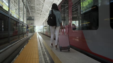 woman walking towards train at station