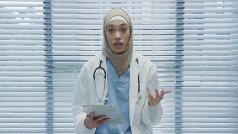 young female doctor using tablet and talking to camera 4k