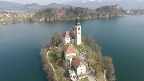 Luftaufnahme,-Blick-Auf-Die-Insel-Mit-Kleiner-Kirche-In-Der-Mitte-Des-Bleder-Sees,-Slowenien