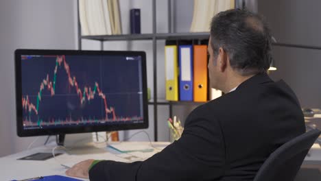 Businessman-monitors-stock-sales-statistics.-Investment-concept.-Office.