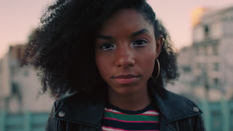 retrato de una hermosa joven mujer afroamericana en el techo al atardecer vistiendo una moda elegante y confiada en la ciudad urbana