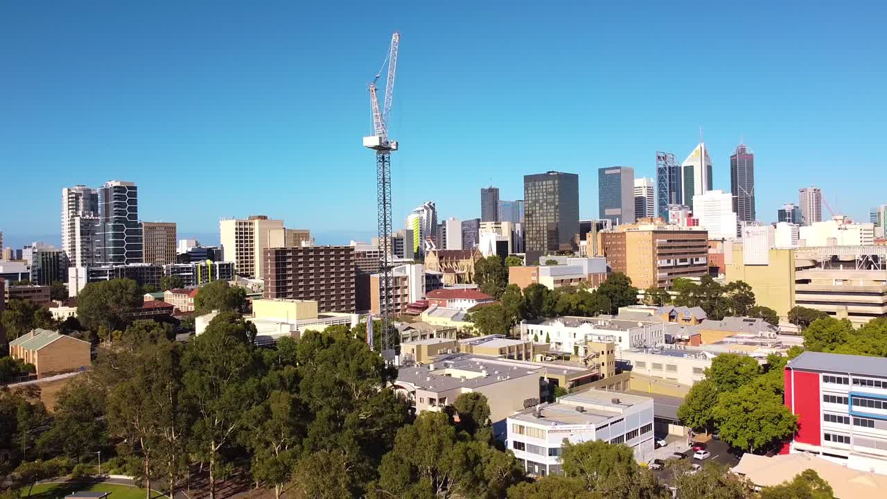 뒷면 에 퍼스 시 건물 들 이 있는 건설 현장 에 있는 타워 크레인 의 느린 공중 역 촬영