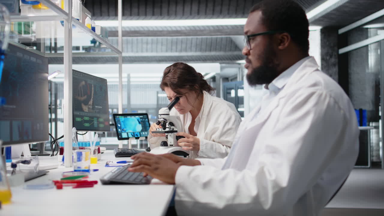 Vertical video Clinical lab technologist uses scientific microscope for disease detection