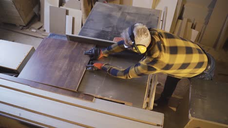 Adult-carpenter-are-using-table-saw-to-cut-in-carpentry-shop.