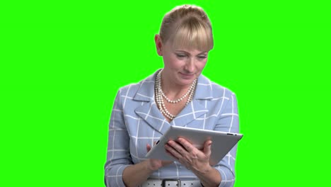 una mujer caucásica madura usando una tableta digital.