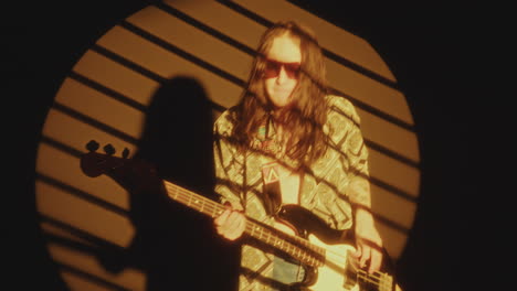 indie musician playing the guitar and rocking in yellow spotlight