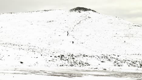 Wanderer-Klettern-Auf-Arktische-Schneebedeckte-Berge-In-Der-Ferne,-Schweden,-Skandinavien