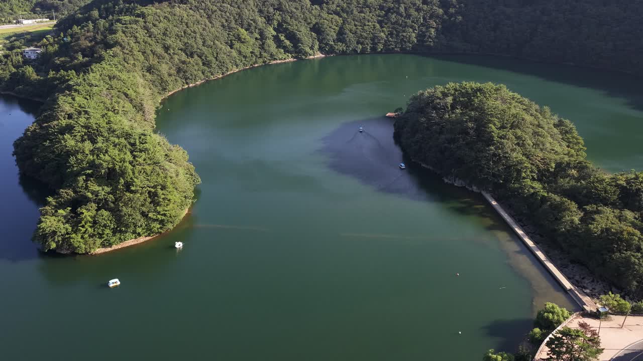 Aerial drone shot panning over a beautiful, calm lake with a forested island