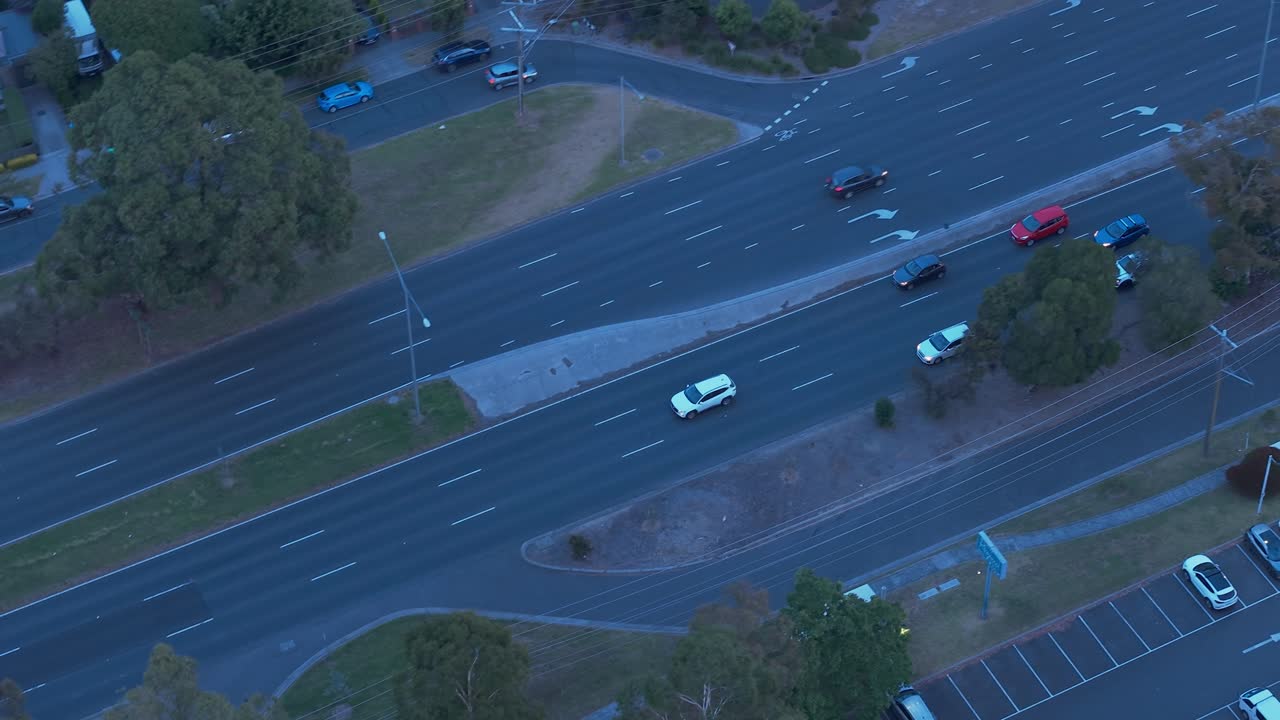 Capture of Melbourne's Croydon roads from above, showcasing evening traffic amidst urban layout. The scene, illuminated under twilight, features dynamic aerial footage providing depth and movement