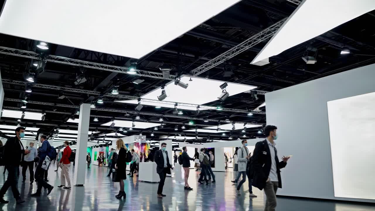 Plano grande angular de uma galeria de arte moderna com pessoas caminhando, mostrando um estilo elegante e contemporâneo