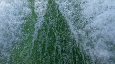 primer plano de la estela de agua detrás de un barco a motor en rápido movimiento en un día de cielo despejado, mar azul, superficie del agua