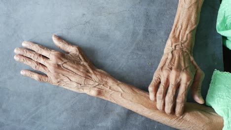 wrinkled hands and arms of an elderly person