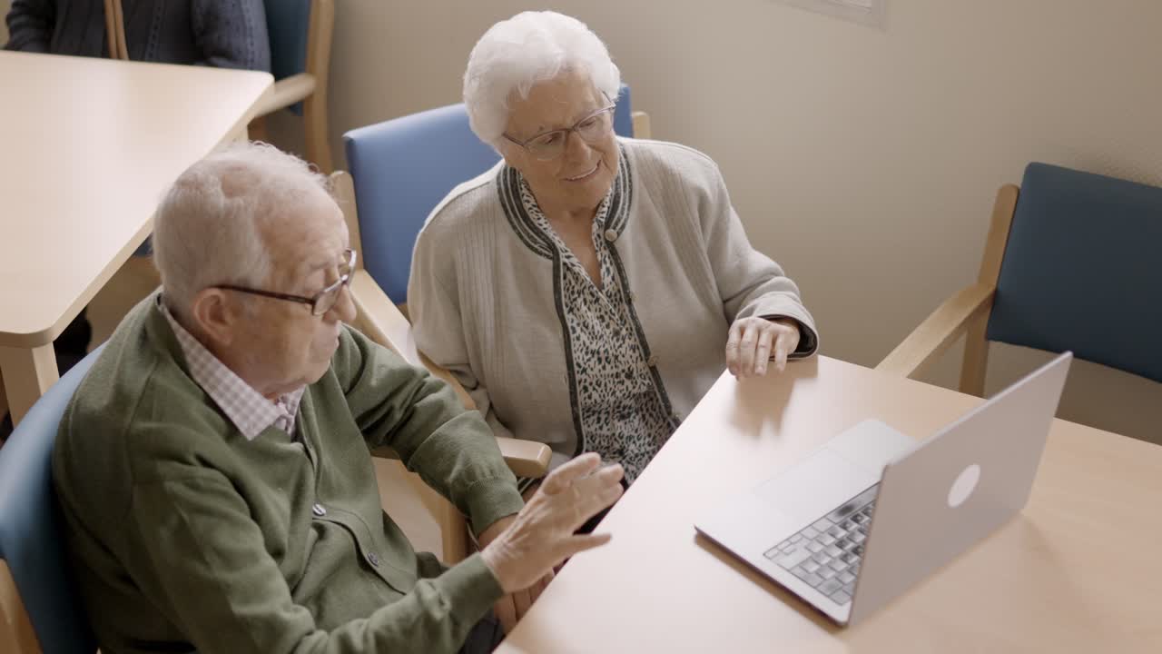 Senior people waving during video call from a nursing home