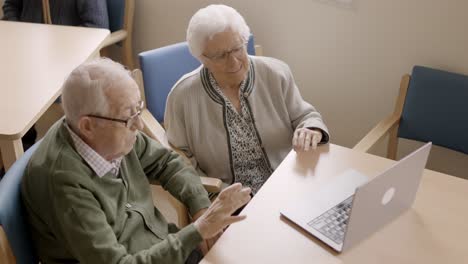 senior people waving during video call from a nursing home
