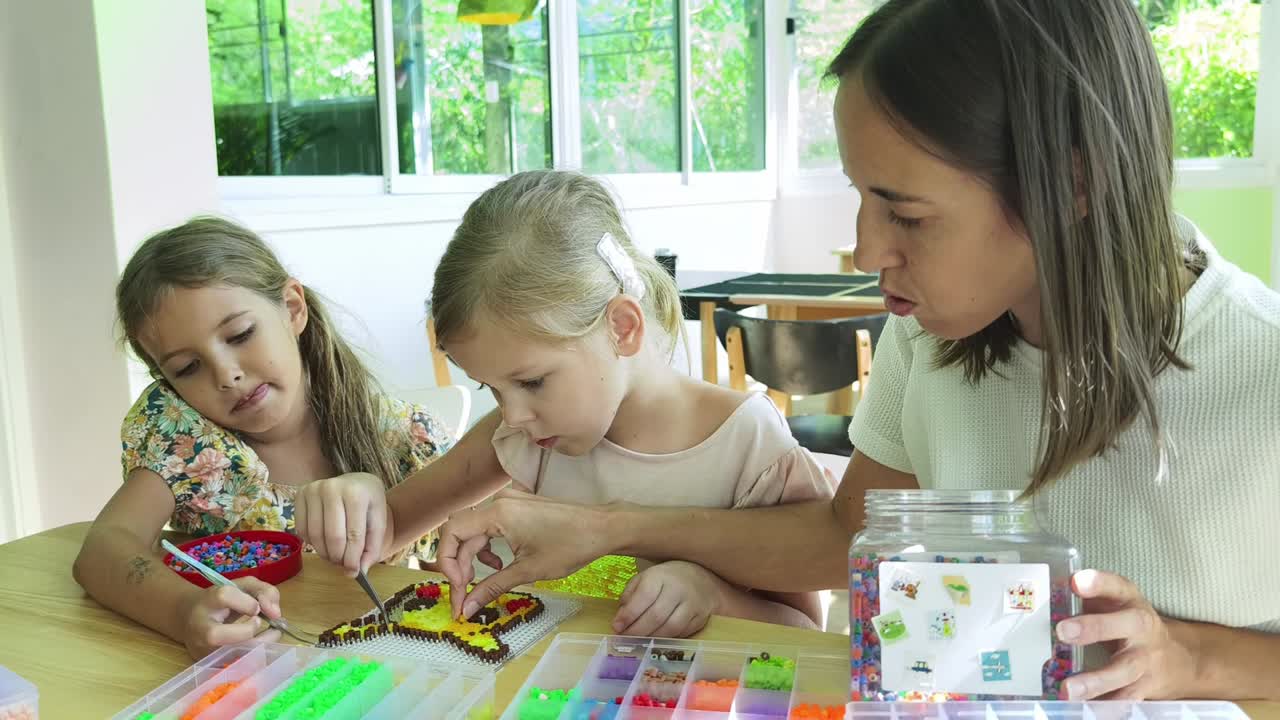 madre e hijas haciendo artesanía de perlas
