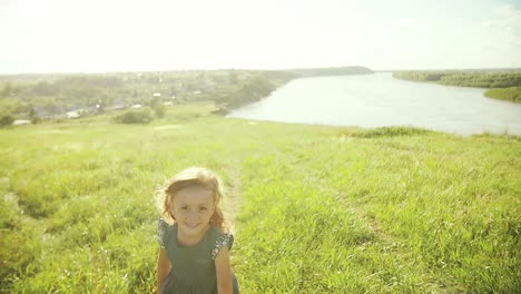 happy girl running in a field by a river