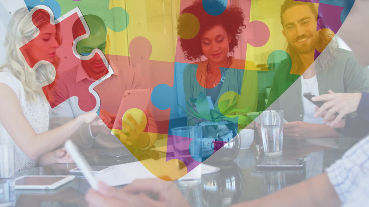 animación de coloridas piezas de rompecabezas corazón sobre colegas de negocios con dispositivos electrónicos