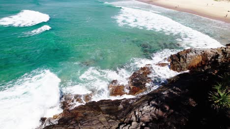 pullback over rocky cliffs with crashing waves in noosa national park, qld australia