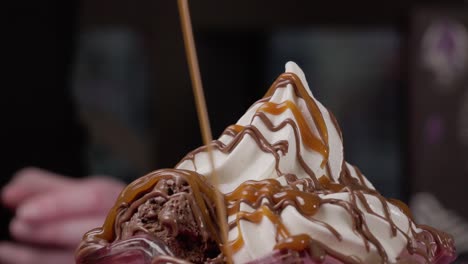 pouring caramel over ice cream dessert