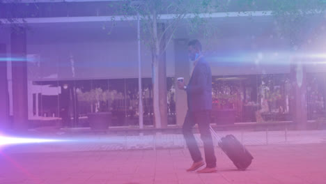 Spots-of-light-against-african-american-man-with-trolley-drinking-coffee-while-walking-on-the-street