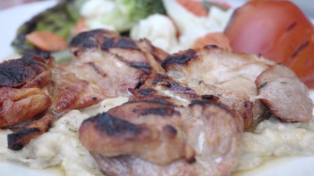Frango Grelhado Servido com Vegetais Assados e Purê.