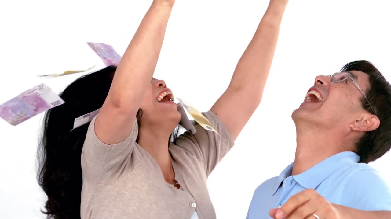 웃는 부자 부부가 돈을 던지고 있습니다.